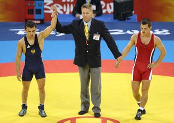 Nazyr Mankiev (L) of Russia is announced as winner after defeating Rovshan Bayramov (R) of Azerbaijan at the men's Greco-Roman 55kg gold medal match at the Beijing 2008 Olympic Games in Beijing, China, Aug. 12, 2008. Nazyr Mankiev won the bout and grabbed the gold medal of the event. (Xinhua Photo)