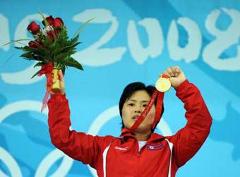 Pak Hyon Suk of the Democratic People's Republic of Korea (DPRK) shows the gold medal at the awarding ceremony of the women's 63kg final of weightlifting at Beijing 2008 Olympic Games in Beijing, China, Aug. 12, 2008. Pak Hyon Suk won the gold medal in this event with a total of 241 kilos. (Xinhua/Yang Lei)