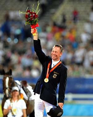 German rider Hinrich Romeike waves on the podium during the awarding ceremony for the individual eventing of the Beijing 2008 Olympic Games equestrian events in the Olympic co-host city of Hong Kong, south China, Aug. 13, 2008. Hinrich Romeike won the gold medal with a total penalty of 54.20. (Xinhua)