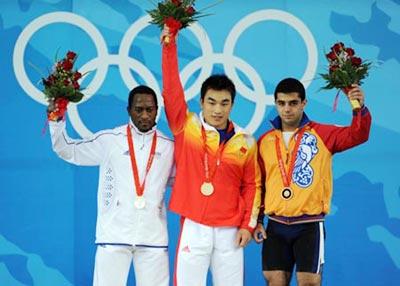 Gold medalist Liao Hui (C) of China, silver medalist Vencelas Dabaya-Tientcheu(L) of France, and bronze medalist Tigran Gevorg Martirosyan of Armenia stand on the podium at the awarding ceremony of the men's 69kg final of weightlifting at Beijing 2008 Olympic Games in Beijing, China, Aug. 12, 2008.(Xinhua Photo)