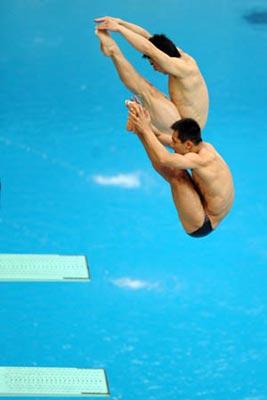 China's Qin Kai (top)/Wang Feng compete during the final of the men's 3m synchro springboard at the Beijing 2008 Olympic Games in the National Aquatics Center, also known as the Water Cube in Beijing, China, Aug. 13, 2008. Qin Kai/Wang Feng won the gold medal with a score of 469.08. (Xinhua/Zhao Peng)