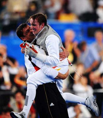 Benjamin Philip Kleibrink (R) of Germany hugs his coach after winning the men's individual foil final of fencing against Ota Yuki of Japan at Beijing 2008 Olympic Games in Beijing, China, Aug. 13, 2008. Kleibrink won the match 15-9 and won the gold medal. (Xinhua Photo/Yang Lei)