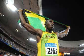Jamaica's Usain Bolt displays the national flag of Jamaica after taking men's 100m final at the National Stadium, also known as the Bird's Nest, during Beijing 2008 Olympic Games in Beijing, China, Aug. 16, 2008. Usain Bolt claimed the title of the event and broke the world record. (Xinhua Photo)