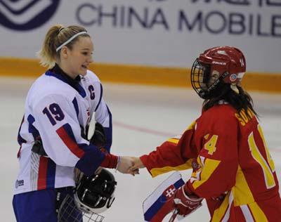 Players of China and Slovakia exchange team flags before their women ice hockey preliminary, the first match at the 24th World Winter Universiade in the Harbin Ice Hockey Gym of Harbin, capital of northeast China's Heilongjiang Province, Feb. 18, 2009. (Xinhua/Zhou Que)