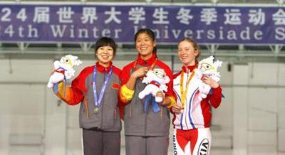 Gold medalist China's Dong Feifei (C) and her teammate silver medalist Fu Chunyan (L) and bronze medalist Poland's Luiza Zlotkowska pose for group pictures during the awarding ceremony for women's 5000m of speed skating in the 24th World Winter Universiade at Heilongjiang Speed Skating Gym in Harbin, capital of northeast China's Heilongjiang Province, Feb. 24, 2009. (Xinhua Photo)