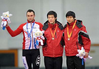 Mo Tae Bum (C) of South Korea takes a photo with his compatriot Lee Kang Seok (R) and Polish Konrad Niedzwiedzki during the awarding ceremony for the men's 1000m final of speed skating in the 24th Winter Universiade at Heilongjiang Speed Skating Gym in Harbin, capital of northeast China's Heilongjiang Province, Feb. 24, 2009. Mo Tae Bum won the title with 1:10.05. Konrad Niedzwiedzki and Lee Kang Seok took the silver and bronze respectively. (Xinhua Photo)