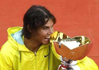 Rafael Nadal of Spain bites his trophy after winning the final of the Monte Carlo Masters tennis tournament in Monaco April 19, 2009. Rafael Nadal defeated Novak Djokovic of Serbia.  (Xinhua/Reuters Photo)