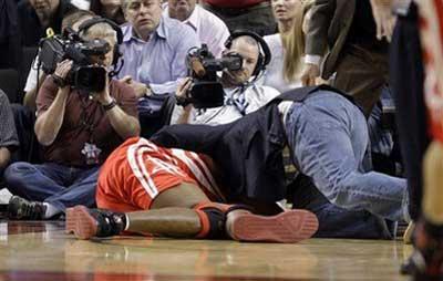 Houston Rockets' Dikembe Mutombo lies on the floor and is attended to after being injured in the first half of an NBA basketball playoff game against the Portland Trail Blazers in Portland, Ore., Tuesday, April 21, 2009. The Trail Blazers defeated the Rockets 107-103.(AP Photo/Rick Bowmer) 