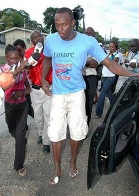 Olympic champion sprinter Usain Bolt is followed by journalists while leaving the Spanish Town Hospital in St. Catherine parish, Jamaica, Wednesday, April 29, 2009. Bolt was treated for minor injuries he received in a car crash on a rain-slicked highway when he lost control of his car and it went off the road. Bolt and an unidentified female passenger were taken to the hospital, though neither was seriously hurt, police Sgt. David Sheriff said.(AP Photo/Bryan Cummings, Jamaica Observer) 