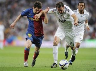 Barcelona's Lionel Messi from Argentina, left, duels for the ball with Real Madrid's Cristoph Metzelder from Germany during their La Liga soccer match at the Santiago Bernabeu stadium in Madrid, Saturday, May 2, 2009. Barcelona won the match 6-2.(AP Photo/Daniel Ochoa de Olza)