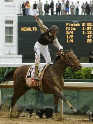 Jockey Calvin Borel raises his crop as he crosses the finish line on Mine That Bird to win the 135th running of the Kentucky Derby at Churchill Downs in Louisville, Kentucky May 2, 2009.(Xinhua/Reuters Photo)