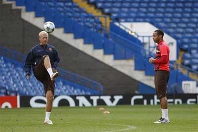 Barcelona's Eidur Gudjohnsen, left, kicks the ball as Thierry Henry looks on during their training session at Stamford Bridge, London, Tuesday, May 5, 2009. Barcelona will play Chelsea in their Champions League semifinal second leg soccer match at Stamford Bridge, Wednesday.(AP Photo/Sang Tan) 