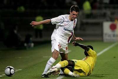 Lyon's Jeremy Toulalan, left, is tackled by FC Nantes's Guirane N'Daw, right, during their French League One soccer match at Gerland stadium, in Lyon, central France, Tuesday, May 12, 2009.(AP Photo/Laurent Cipriani) 