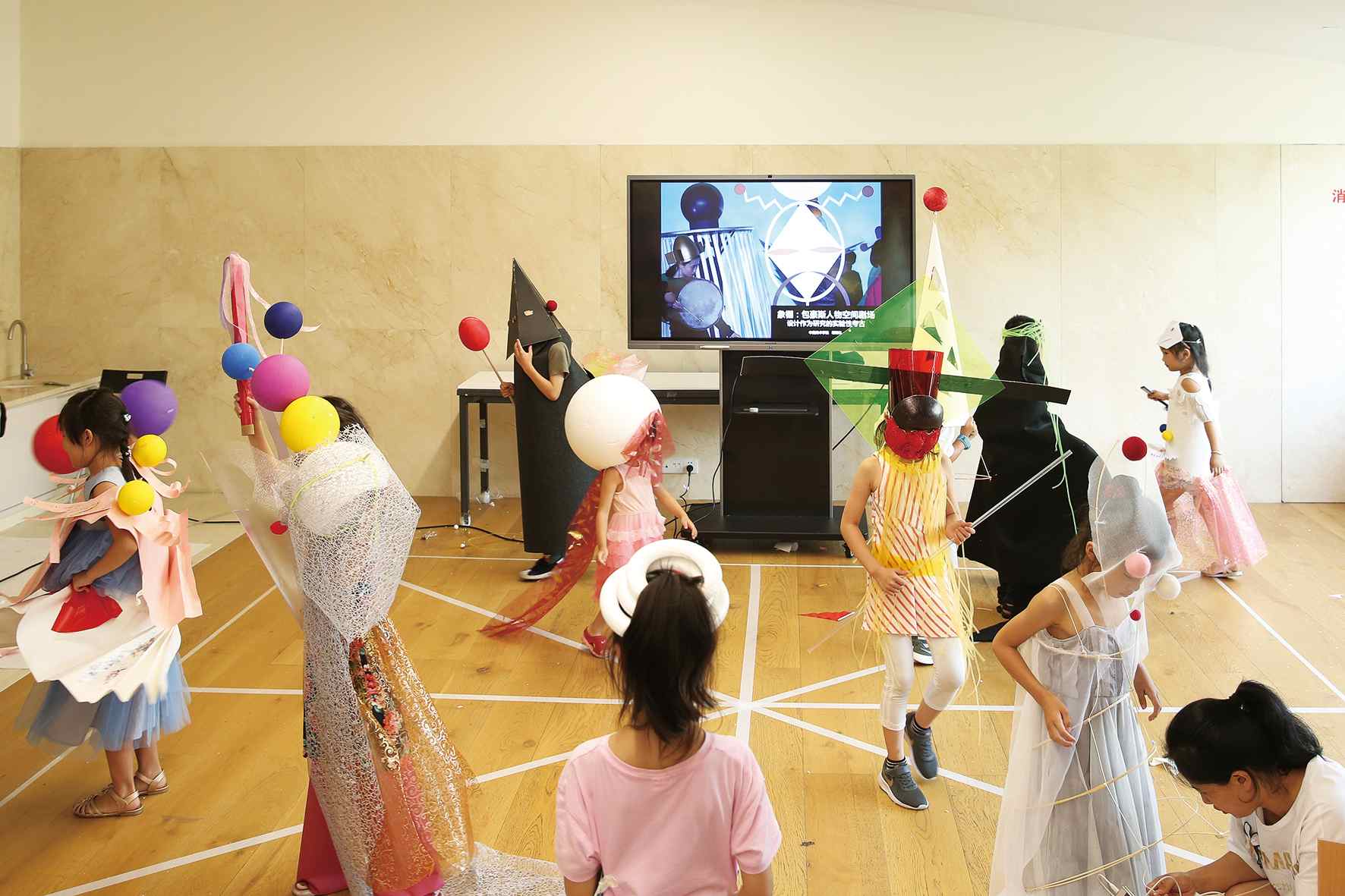 在中國美術學院美術館舉辦的“包豪斯人物空間劇場兒童工坊”公教活動上，孩子們展示自己做的服裝。