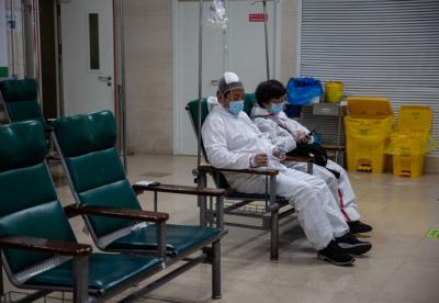 3月19日，武漢協和醫院輸液室內，身著防護服輸液的患者。中青報·中青網記者 李崢苨/攝