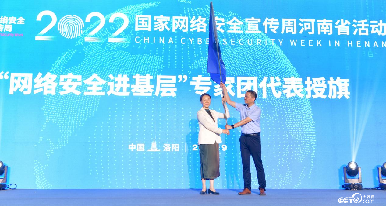 河南省委網信辦主任郭岩松（左）向“網絡安全進基層”專家團代表授旗