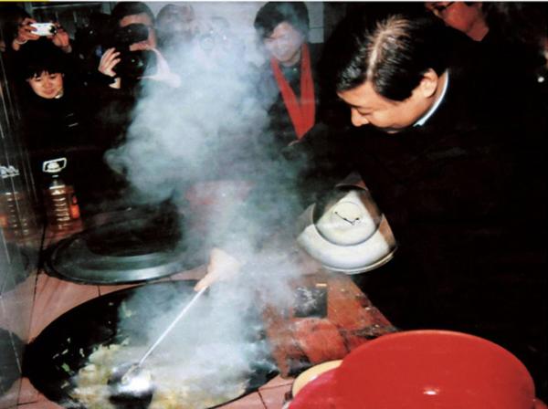 2007年1月，時任浙江省委書記習近平（右一）在浙江省慶元縣屏都鎮敬老院為老人們炒菜。