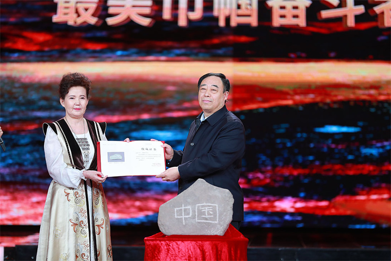 館藏儀式：中國國家博物館黨委書記、副館長單威（右一）與新疆婦聯代表古麗夏提（左一）交接中國石與收藏證書