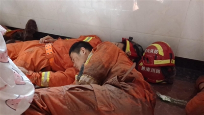 連續參與救援11個小時後，消防救援人員和衣躺在地上休息