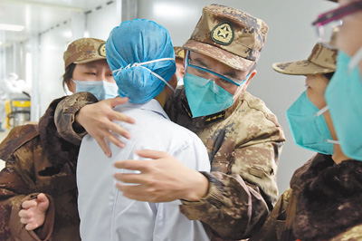 戰友們擁抱軍隊援助湖北醫療隊隊員吳亞玲（左二）。 　　范顯海攝（影像中國）