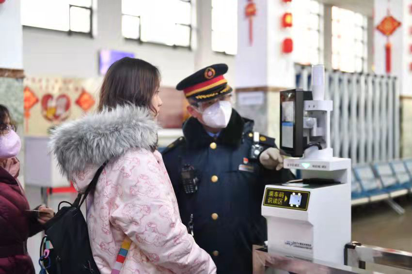 測溫機器人對進站乘車的旅客測量體溫，並提醒旅客佩戴口罩