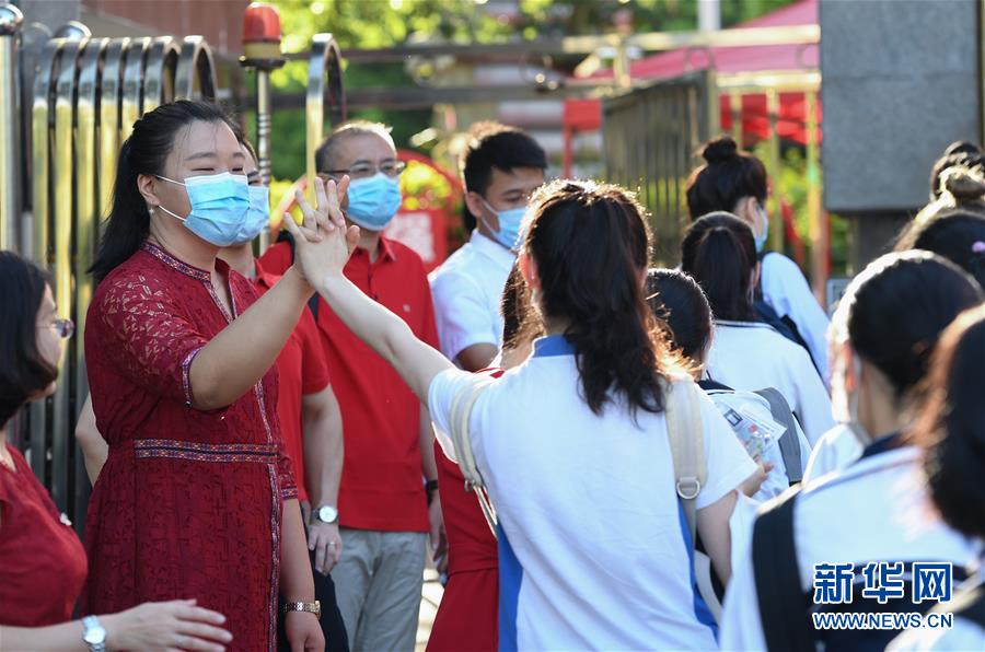 7月7日，在深圳市福田中學考點外，老師為即將參加高考的考生加油。 當日，2020年高考拉開帷幕。 （新華社）