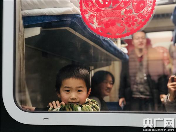 1月10日，在春運首趟增開的北京—南通K4051次列車上，一位小乘客透過車窗向外張望（央廣網記者 王晶 攝）