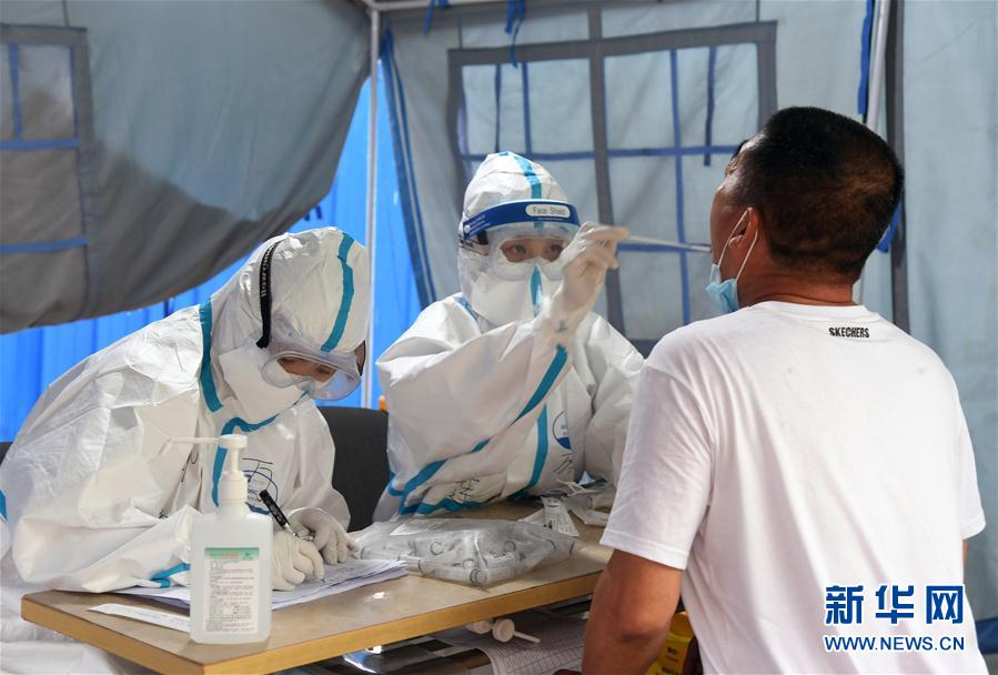 6月18日，在海淀區區級核酸檢測採樣點，醫護人員為市民進行核酸檢測採樣。 新華社記者 任超 攝