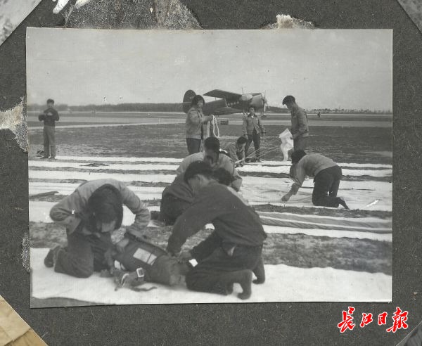 湖北飛機跳傘運動代表隊。升空跳傘的絕對安全要求運動員做到“嚴如包公，心細如發”。1959年，運動員在武昌南湖機場檢查裝備，折疊傘衣、傘繩，進行嚴格的疊傘訓練