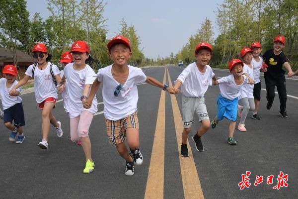 小志願者們在軍運會公路自行車和馬拉松賽道的起終點，模擬百米比賽衝刺跑。記者程艷 攝