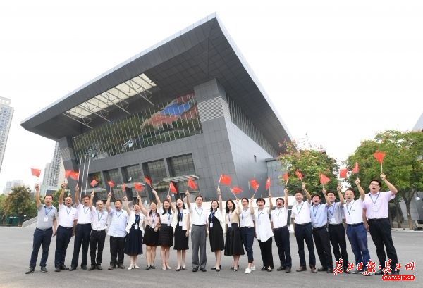 江漢大學志願者在體育館前為軍運會加油：“軍運會，江大歡迎您！” 記者高勇 攝