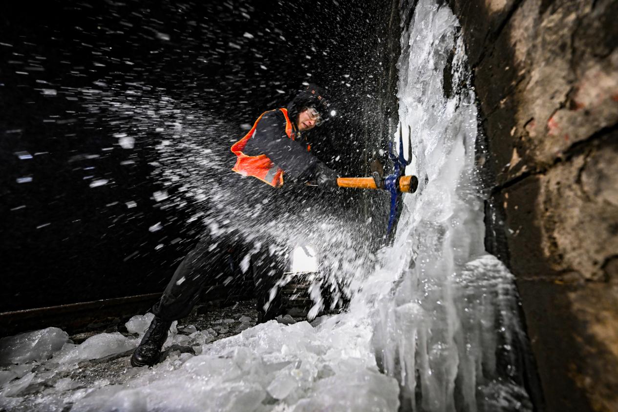 　　工友正在敲擊凍結在隧道內的側壁冰柱。（圖片由太原局太原工務段趙哲昌提供）