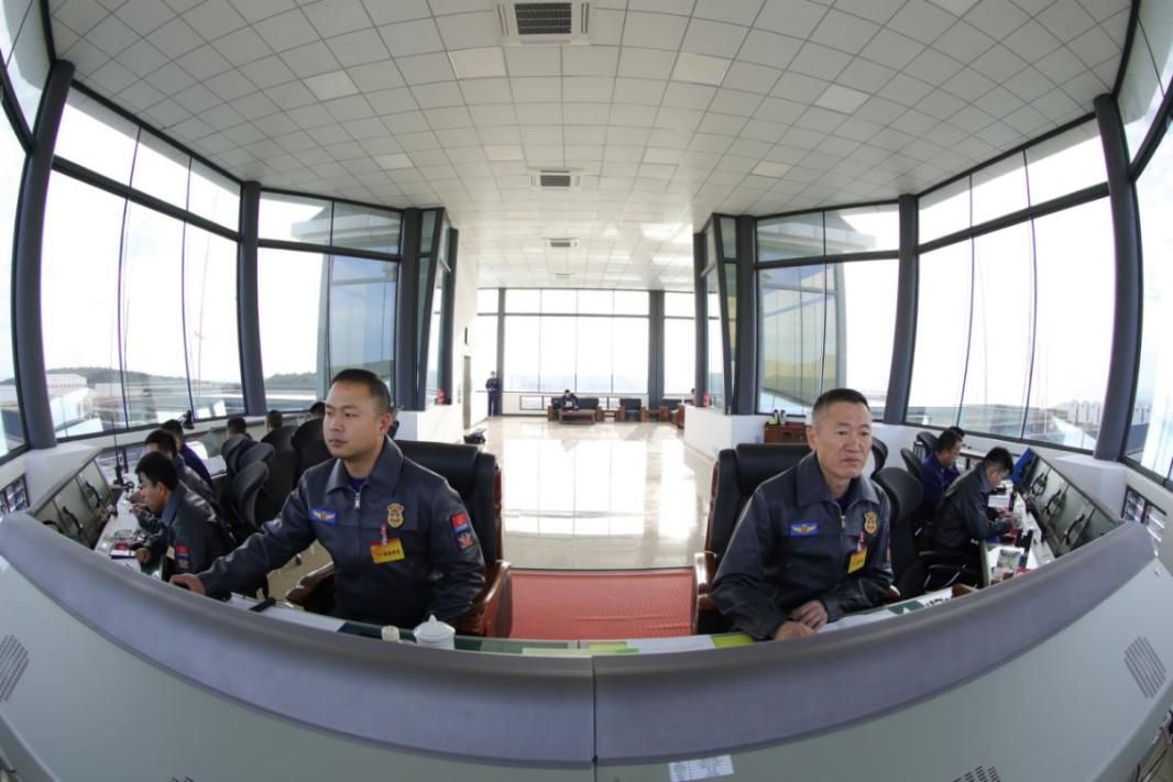 郭勝（左一）在塔臺指揮直升機飛行