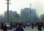飛機墜毀的居民區上空升起濃煙，眾多當地人在觀望