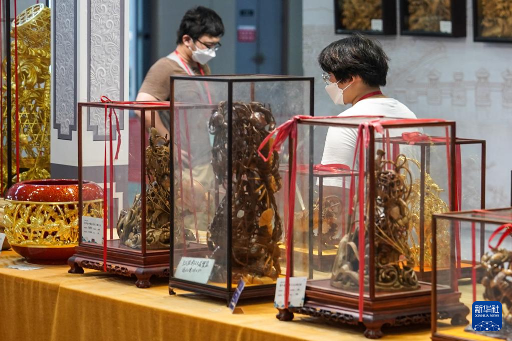 8月18日，觀眾在第二屆中國工藝美術博覽會參觀木雕藝術展品。