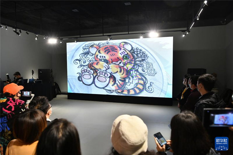 11月18日，與會者在北京舉行的2022中國壬寅（虎）年金銀紀念幣品鑒會上觀看紀念幣宣傳片。