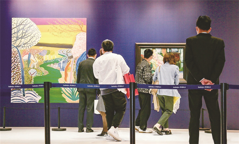 蘇富比展臺展出王俊傑創作的油畫《夕陽之河》與愛德華·蒙克創作的油畫《藤椅上的模特》，吸引不少觀眾駐足觀賞。    中國國際進口博覽局供圖