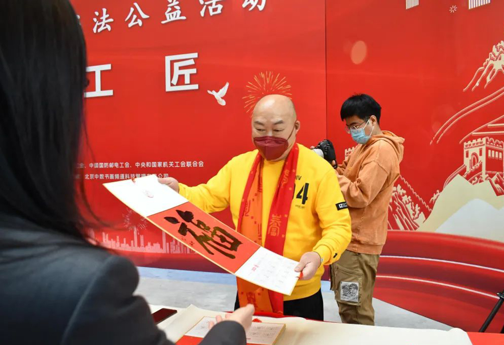 中國書法家協會理事洪厚甜向勞模代表送“福”字