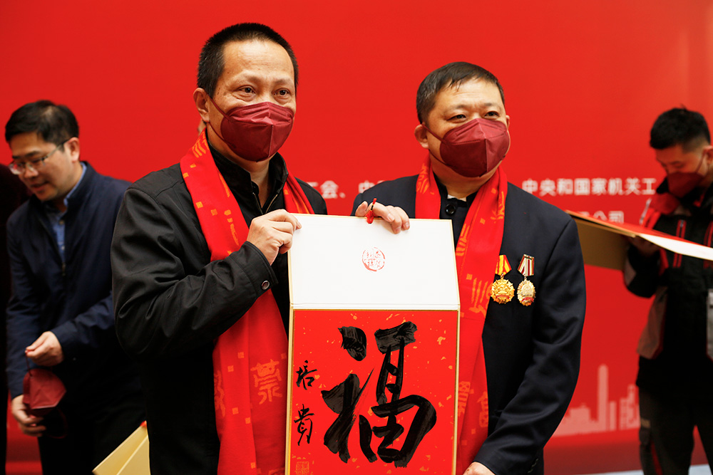 中國書法家協會副主席葉培貴現場向勞模代表送“福”字