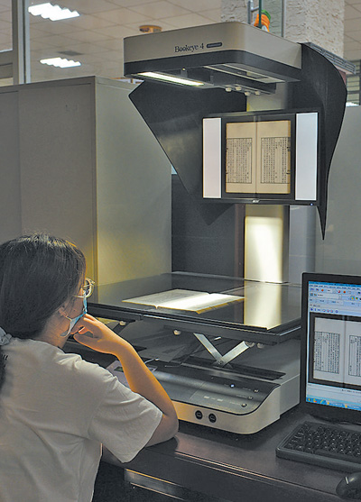 內蒙古圖書館，工作人員正在將古籍進行數字化管理。